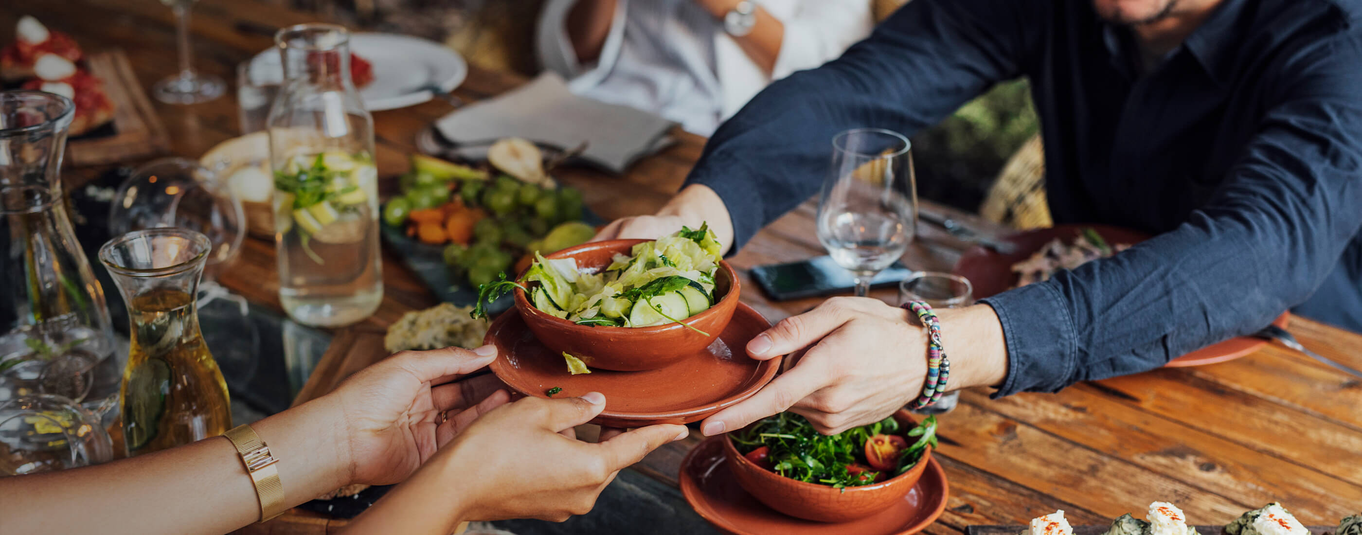 A group of people passing food across the table at and ocean friendly restaurant